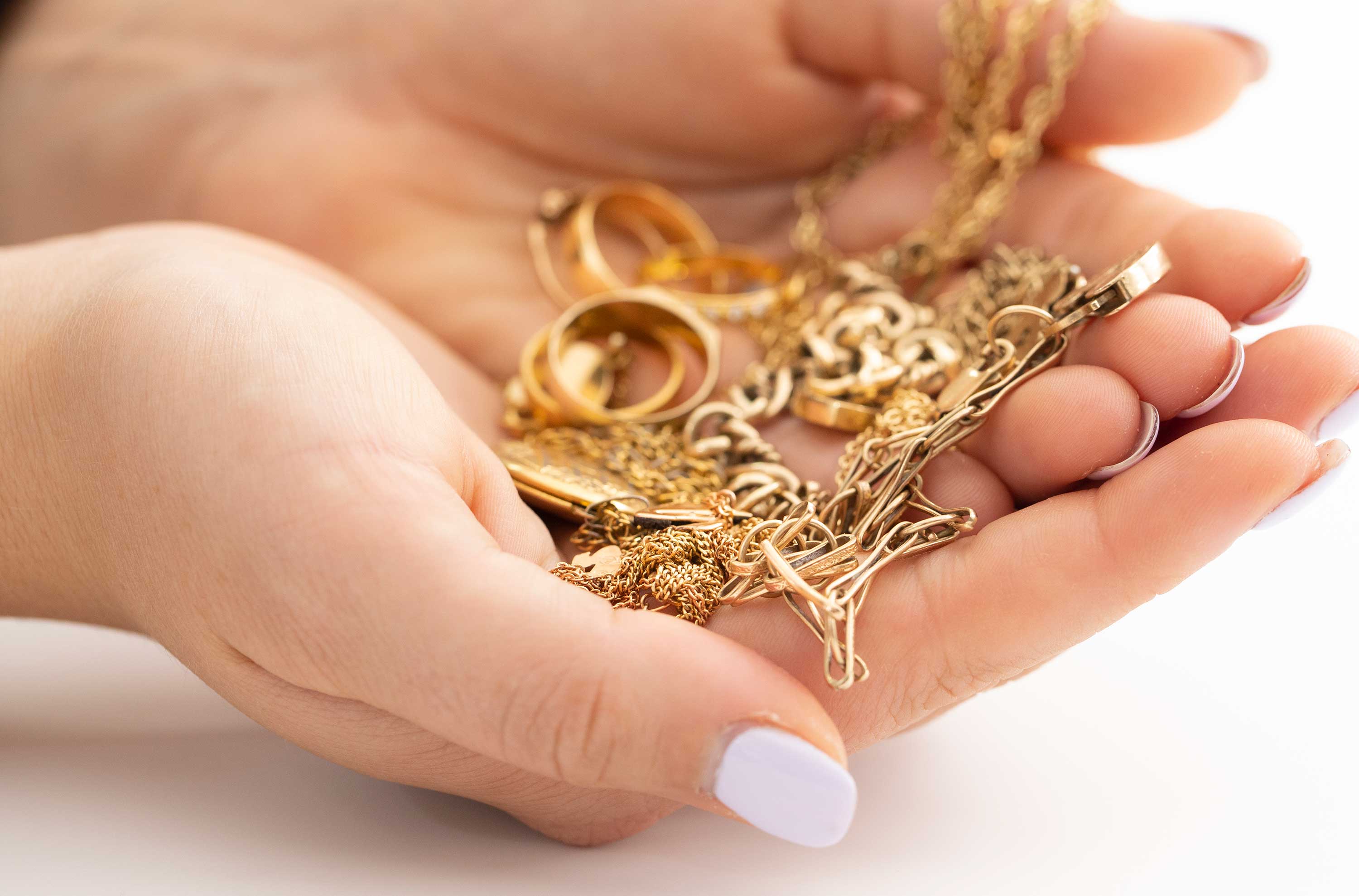 Gold jewellery in hands that the Perth Mint might buy back.