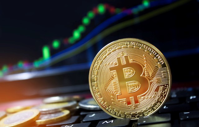 an image of a bitcoin resting on a laptop keyboard.