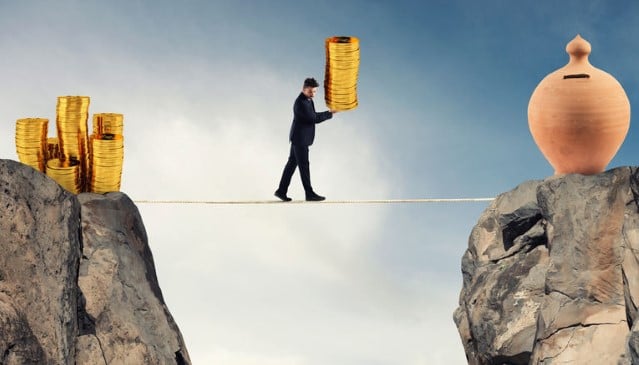 a man on a tightrope carrying coins