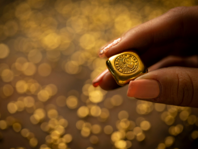 a female hand holding a Perth Mint 1/2 ounce bar