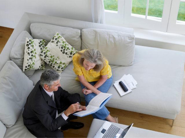 two retirees on the couch  look at their superannuation